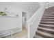 Bright and airy foyer with a staircase, decorative wall art, and a comfortable bench seat at 6699 Alder Rd, Harmony, FL 34773