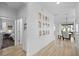 Hallway showcasing wood-look tile floors, neutral decor, and a decorative photo gallery on the wall at 6699 Alder Rd, Harmony, FL 34773