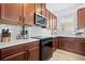 A modern kitchen featuring wood cabinets, a white countertop, tile backsplash, and stainless steel appliances at 6699 Alder Rd, Harmony, FL 34773