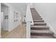 Inviting foyer with a staircase, neutral decor, wood-look tile floors, and a decorative wall collage at 6699 Alder Rd, Harmony, FL 34773