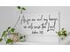 A decorative sign with a meaningful quote displayed on the wall, accompanied by potted plants at 6699 Alder Rd, Harmony, FL 34773