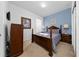 Comfortable bedroom with a queen bed, soft carpet, and a blue accent wall featuring decorative artwork and sconce lighting at 7735 Teascone Blvd, Kissimmee, FL 34747