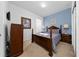 Cozy bedroom with a wooden bed frame, blue accent wall, and natural light at 7735 Teascone Blvd, Kissimmee, FL 34747