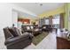 Bright living room featuring leather sofas, tile floors, and sliding glass doors to the outside at 7735 Teascone Blvd, Kissimmee, FL 34747