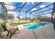 Screened-in pool area with brick pavers, seating, and a clear blue pool at 7735 Teascone Blvd, Kissimmee, FL 34747