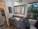 Bathroom featuring a modern vanity with marble countertop, a decorative mirror, and natural lighting at 832 Whalebone Bay Dr, Kissimmee, FL 34741