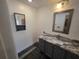 Bathroom featuring a vanity with marble countertop, a decorative mirror, and tiled floor at 832 Whalebone Bay Dr, Kissimmee, FL 34741