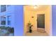 Well-lit entryway with a green door, a small plant, and a wall-mounted light fixture at 8824 Grand Palms Cir # A, Kissimmee, FL 34747