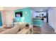 Open floor plan with a bright turquoise accent wall and a breakfast bar to the kitchen at 8824 Grand Palms Cir # A, Kissimmee, FL 34747