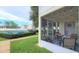 Cozy screened-in patio with string lights, furniture, and a view of the community tennis court at 8824 Grand Palms Cir # A, Kissimmee, FL 34747