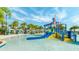 Community water park features a splash pad with a slide and dumping bucket, surrounded by lounge chairs and palm trees at 8962 Hilton Ridge Ave, Kissimmee, FL 34747