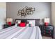 Cozy bedroom featuring decorative wall art above a neatly made bed, flanked by dark nightstands with matching lamps at 8984 Cuban Palm Rd, Kissimmee, FL 34747