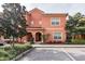 Charming two-story home with a peach exterior, well-manicured landscaping, and a parking spot at 8984 Cuban Palm Rd, Kissimmee, FL 34747