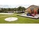 Community playground with colorful play structures, sandy volleyball court, and grassy areas at 8984 Cuban Palm Rd, Kissimmee, FL 34747