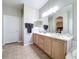 Bathroom with double sinks, large vanity, a doorway, and a peek into the main bedroom suite at 901 Shorehaven Dr, Poinciana, FL 34759