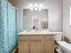 Well-lit bathroom with a clean vanity, a large mirror, and a floral patterned shower curtain at 901 Shorehaven Dr, Poinciana, FL 34759