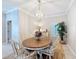 This dining room features an oval wood table, white chairs with decorative cushions, and a decorative chandelier at 901 Shorehaven Dr, Poinciana, FL 34759