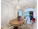 This dining room has an open layout, a wood table, white chairs with decorative cushions, and a decorative chandelier at 901 Shorehaven Dr, Poinciana, FL 34759