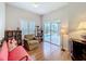 Cozy living room features wood floors, a comfortable chair, and sliding glass doors to the pool area at 901 Shorehaven Dr, Poinciana, FL 34759