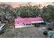 Aerial view of a charming single-story home with red roof, covered parking, and spacious yard at 912 Ne 144Th Ct, Silver Springs, FL 34488