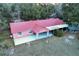 An aerial view showcases this single-story home with covered porch, a carport and expansive yard at 912 Ne 144Th Ct, Silver Springs, FL 34488