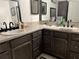 Bathroom featuring double sinks with dark wood cabinets and ample countertop space for all your needs at 912 Ne 144Th Ct, Silver Springs, FL 34488