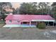 Exterior elevation of a pink single Gathering ranch style home with covered carport and front patio at 912 Ne 144Th Ct, Silver Springs, FL 34488