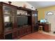 A formal living room with a large entertainment center, wood floors, computer desk, and white door at 912 Ne 144Th Ct, Silver Springs, FL 34488