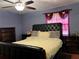 Bedroom featuring a luxurious black upholstered headboard, plush bedding, and dark wood nightstands at 912 Ne 144Th Ct, Silver Springs, FL 34488