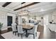 An open-concept dining room features a large table under modern chandelier between the kitchen and entrance at 10196 Bucklow Hill Dr, Orlando, FL 32832