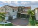 Stunning two-story home with a red tile roof, stone accents, and a brick-paved driveway at 10196 Bucklow Hill Dr, Orlando, FL 32832