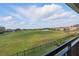 Picturesque view of the community's green space and water feature from the home's black railed balcony at 10196 Bucklow Hill Dr, Orlando, FL 32832