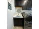 Laundry room featuring a sink, dark cabinets, and a decorative 'Laundry Room' sign at 10902 Citron Oaks Dr, Orlando, FL 32836