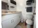Clean bathroom featuring updated vanity, mirror, toilet, and neutral tile flooring at 113 Las Brisas Way, Kissimmee, FL 34743