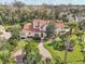 Beautiful aerial view of the property showcasing the home's red tile roof, mature landscaping, and brick driveway at 1211 Aquila Loop, Kissimmee, FL 34747