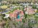 Aerial view showcasing a large estate with a swimming pool, a guesthouse, and a beautiful red tile roof at 1211 Aquila Loop, Kissimmee, FL 34747