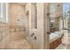 Large walk-in shower with travertine tile, shower head, and a glass door at 1211 Aquila Loop, Kissimmee, FL 34747