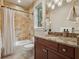 Bathroom with granite vanity, decorative lighting, and tiled shower with tub at 1211 Aquila Loop, Kissimmee, FL 34747