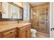 Bathroom featuring a vanity with granite countertop and glass enclosed shower at 1211 Aquila Loop, Kissimmee, FL 34747