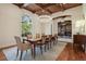 Formal dining room featuring wood-beamed ceilings, chandelier, and access to the living room with fireplace at 1211 Aquila Loop, Kissimmee, FL 34747