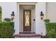 Close-up of the home's inviting front door with decorative glass, sidelights, and stylish lighting fixtures at 1211 Aquila Loop, Kissimmee, FL 34747