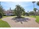 Circular driveway with mature trees, a well-maintained lawn, and a beautiful home at 1211 Aquila Loop, Kissimmee, FL 34747