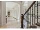 Bright hallway featuring travertine flooring, arched doorways, and a staircase with iron railing details at 1211 Aquila Loop, Kissimmee, FL 34747