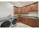 Functional laundry room with modern washer and dryer, ample cabinetry, and granite countertop at 1211 Aquila Loop, Kissimmee, FL 34747