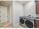 Functional laundry room with modern washer and dryer, ample cabinetry, and granite countertop at 1211 Aquila Loop, Kissimmee, FL 34747