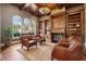 Inviting living room with wooden ceiling, custom built-ins, fireplace, and natural light at 1211 Aquila Loop, Kissimmee, FL 34747