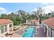 Aerial view of a luxury outdoor pool and spa with lush landscaping and connecting pergolas at 1211 Aquila Loop, Kissimmee, FL 34747