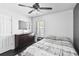 Cozy bedroom featuring wood floors, a dresser with mirror, and a ceiling fan at 1240 Beth Ln, St Cloud, FL 34772