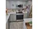 Well-lit kitchen featuring stainless steel appliances, gray cabinets, and stylish backsplash at 1422 Indiana Ave, St Cloud, FL 34769