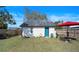 View of a shed in the backyard, with a painted door, next to a well-kept yard at 1422 Indiana Ave, St Cloud, FL 34769